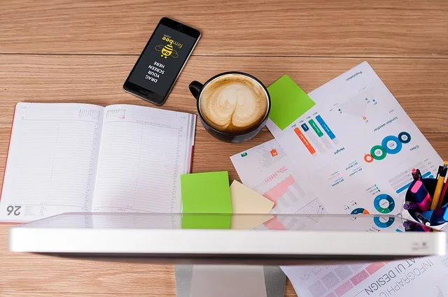 a table with papers, diary and a cup of coffee. 