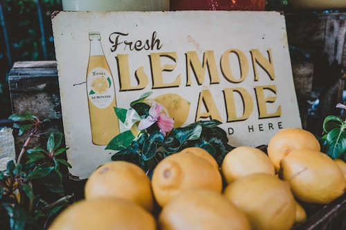 Lemons and a board saying lemonade - a graphic for a blog post on ways for kids to make money fast