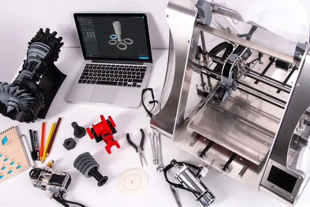 a table with a cnc machine, laptop and a few other tools working on CNC Projects to Sell
