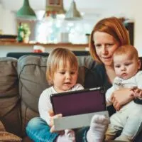 stay at home mom with a child on the side with a screen - blog graphic for a post on Side hustle for single moms