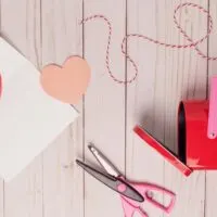 on a board, there are hearts, scissors and craft supplies. Blog post onValentine crafts to make and sell