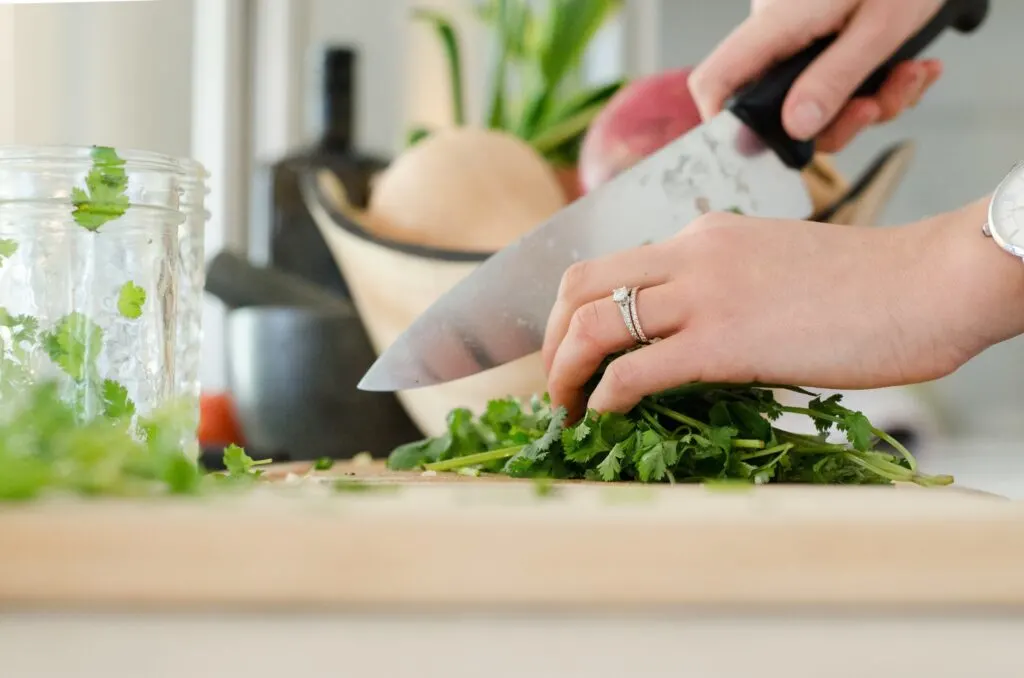 hand pictures that are cutting veggies on a board