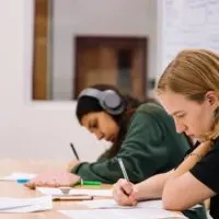 Two students on a desk studying. Blog post graphic for a blog on How to make money as a teenager without a job