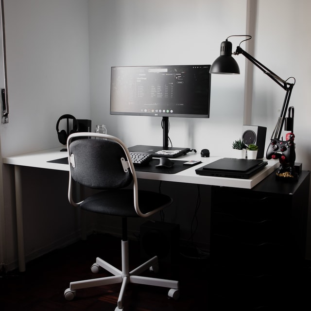 A work desk - a table with laptop, lamp and a chair in total black..graphic for a post on highest paying work from home jobs without a degree