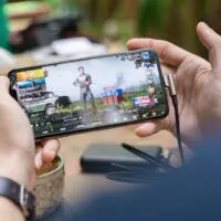 a person holding mobile and playing games. photo for a post on games that instantly pay through paypal