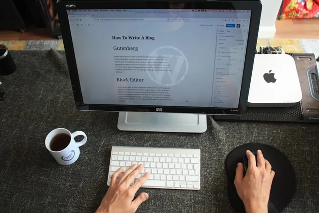 This image shows someone reading how to write a blog on his/her laptop. used for a post on art side hustle