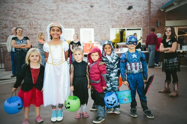 In this image you can see kids of different age wearing different fancy costumes for halloween.