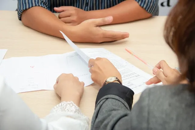 In this 3 people are discussing on something written on the paper