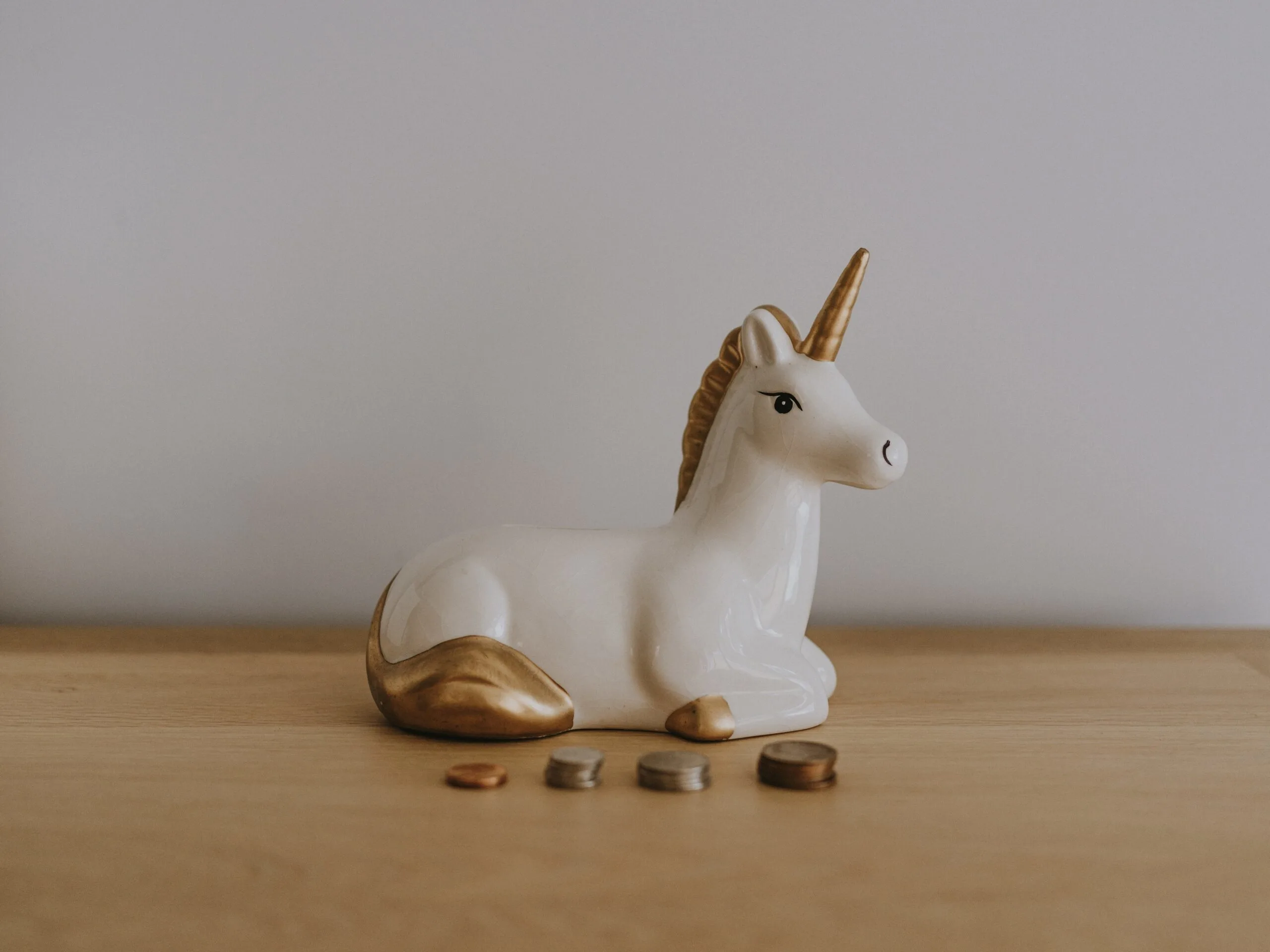 a unicorn with money in front of coins