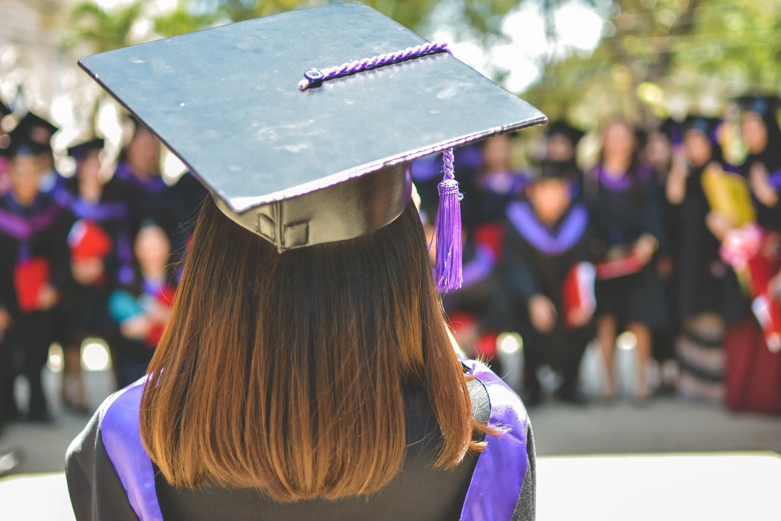 A woman with a college degree hat facing the other side