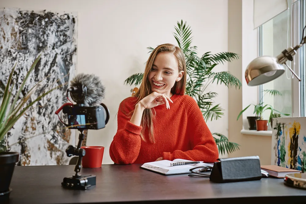 Beautiful blogger. Female young vlogger recording social media video and smiling while looking at camera. Social Media. Blog. Youtube