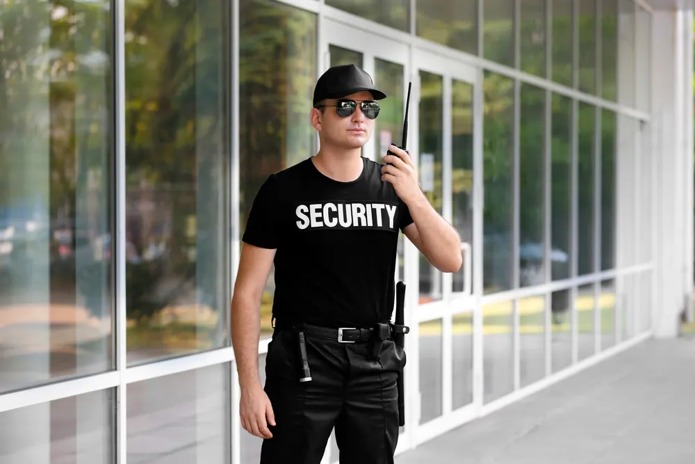 Male security guard with portable radio outdoors