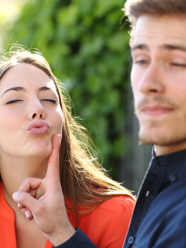 Woman trying to kiss a man and he is rejecting her outdoor in a park