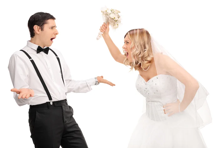 Studio shot of a young bride yelling to the groom and threatening him isolated on white background