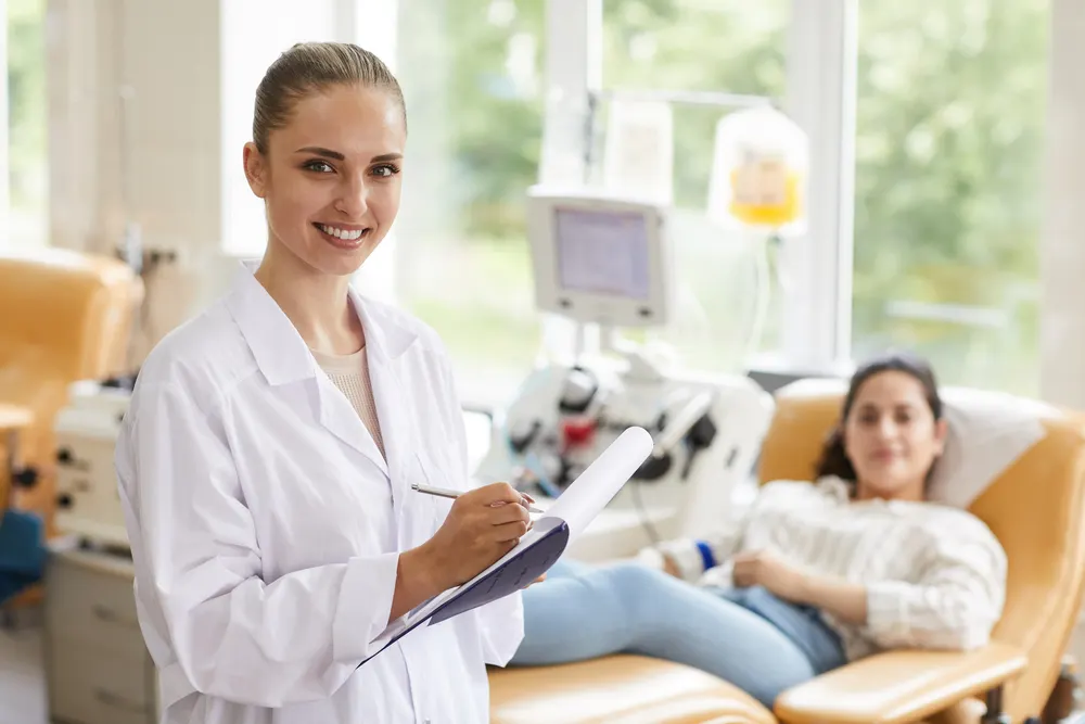 Portrait of female doctor smiling at camera while examining patient at the hospital