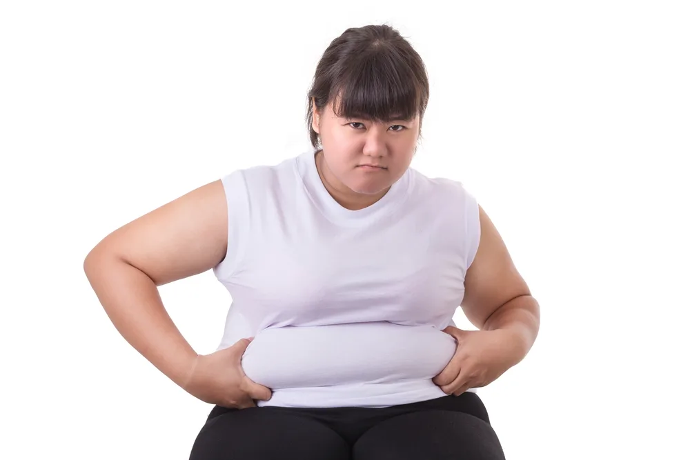Fat Asian woman wear white t-shirt worried about her body size isolated on white background