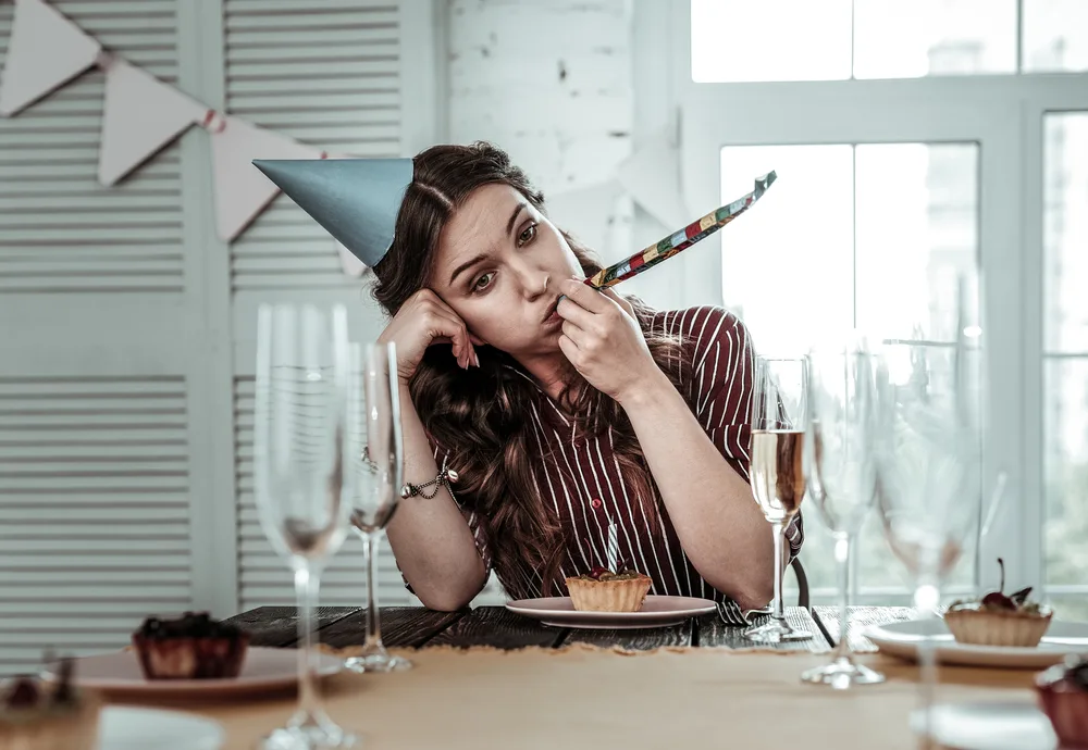 Unhappy party. An upset drunk woman celebrating her birthday party alone