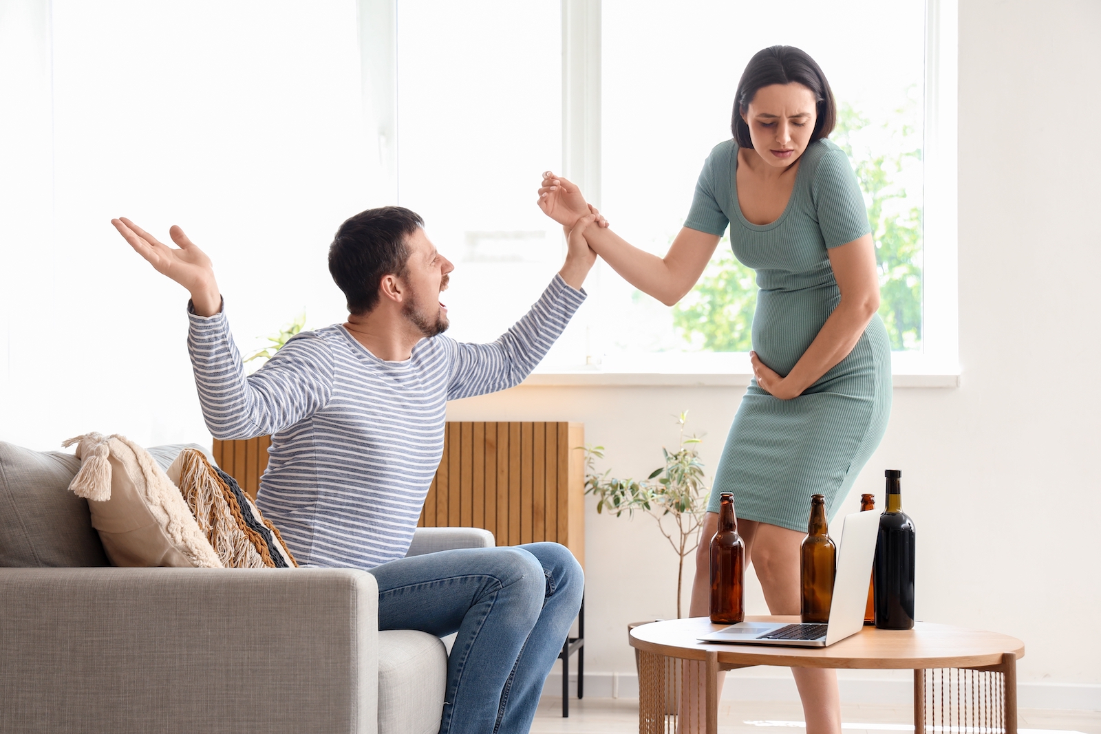 Drunk husband fighting with his pregnant wife at home. Domestic violence concept