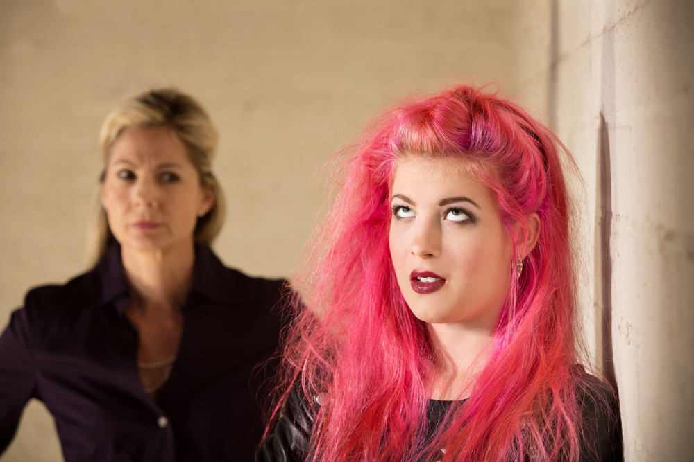 Annoyed girl in pink hair with upset parent