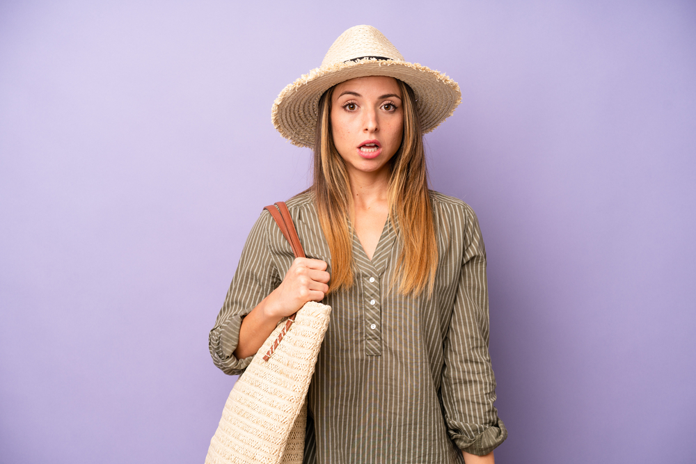 pretty caucasian woman looking very shocked or surprised. summer and hat concept
