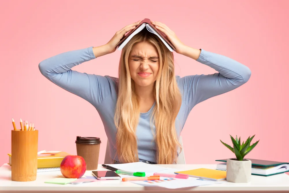 Overworking,Concept.,Tired,Young,Woman,Holding,Book,On,Her,Head,