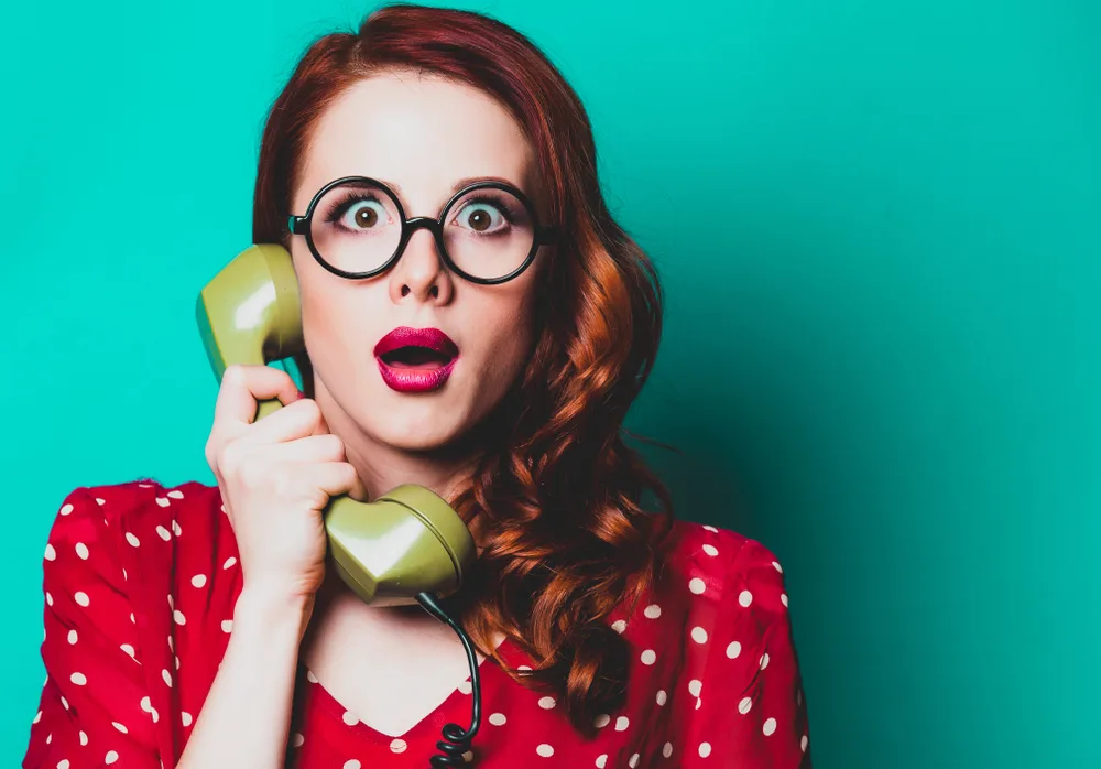 Young,Redhead,Housewife,With,Talking,By,Phone,And,Holding,Handset