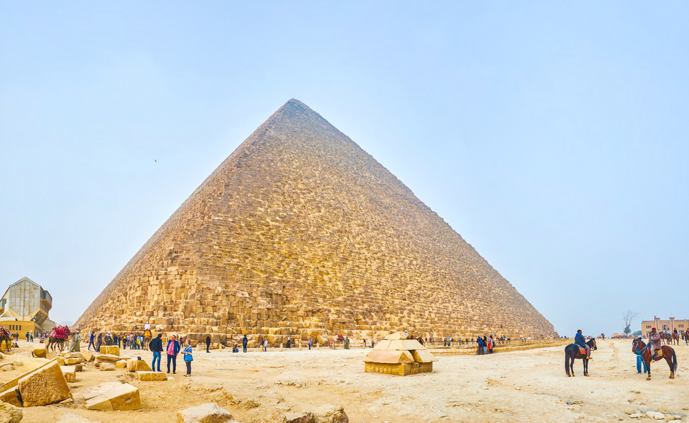 GIZA, EGYPT - DECEMBER 20, 2017: The crowds of tourists at the foot of the Pyramid of Khufu, the biggest Pyramid in complex, on December 20 in Giza