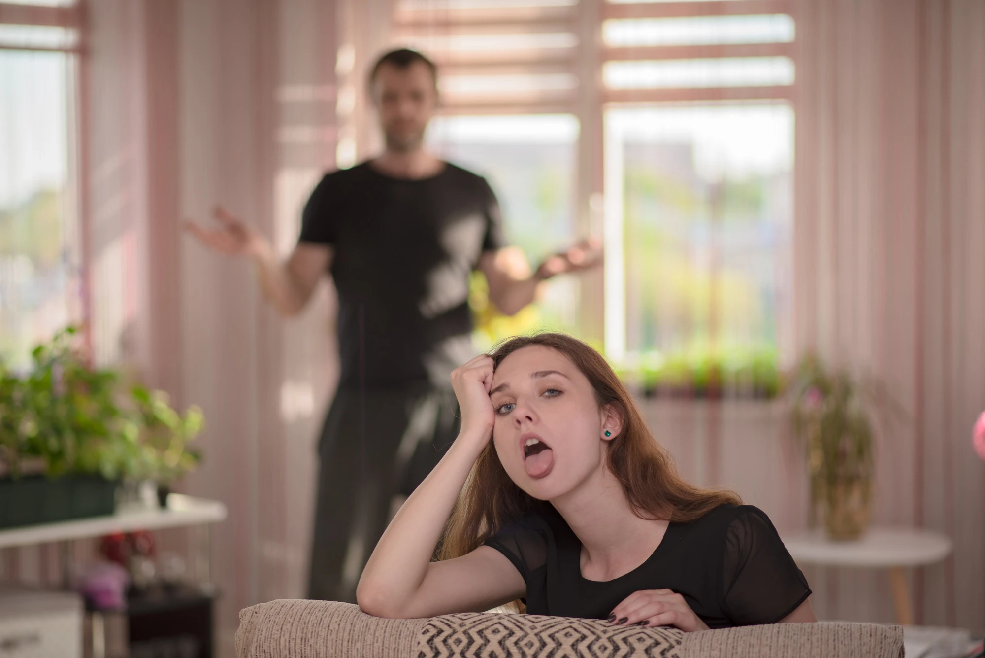 I'm tired of listening to you. Family conflict between father and daughter. daughter sits right in front of the camera and looks displeased.