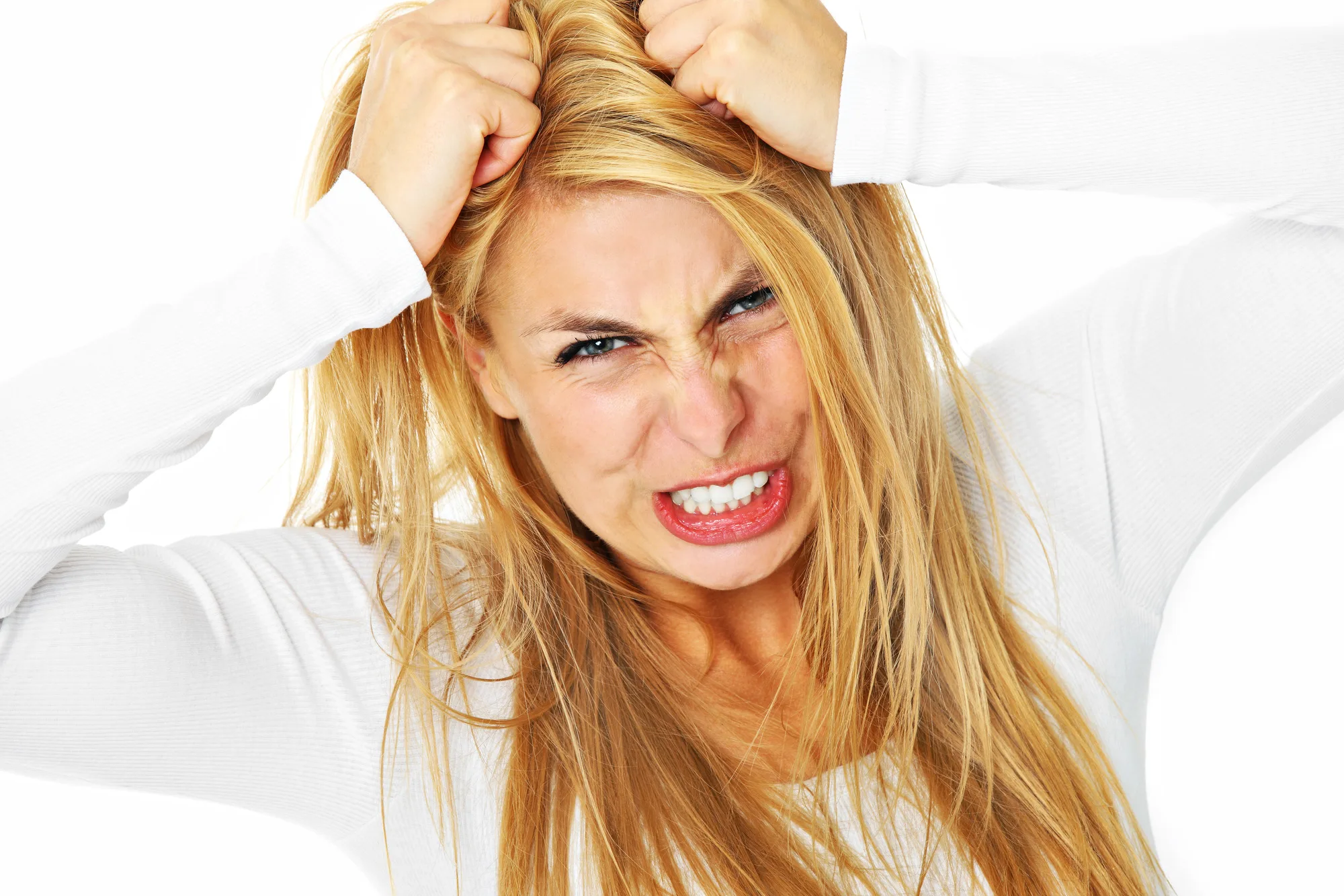 A picture of a young depressed woman tearing out her hair over white background