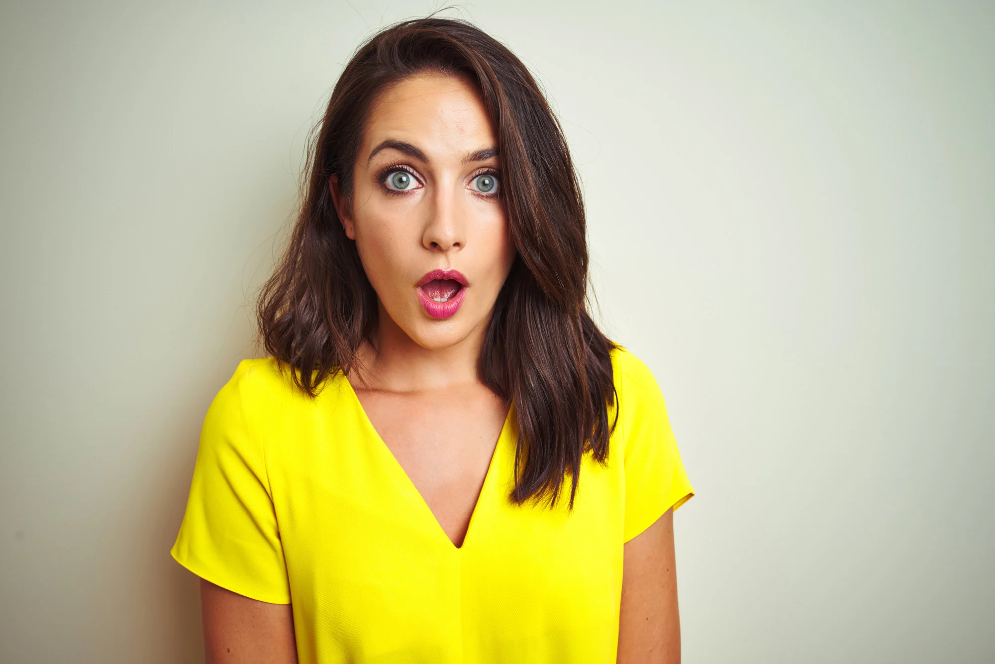 Young beautiful woman wearing yellow t-shirt standing over white isolated background afraid and shocked with surprise expression, fear and excited face.