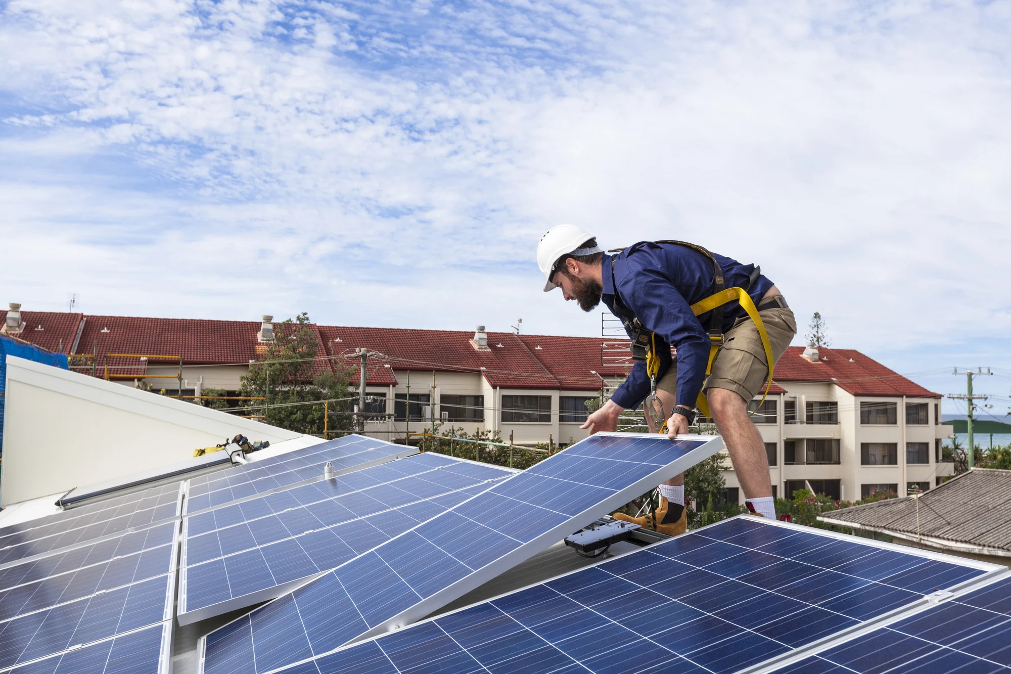 Solar panel technician installing solar panels on roof