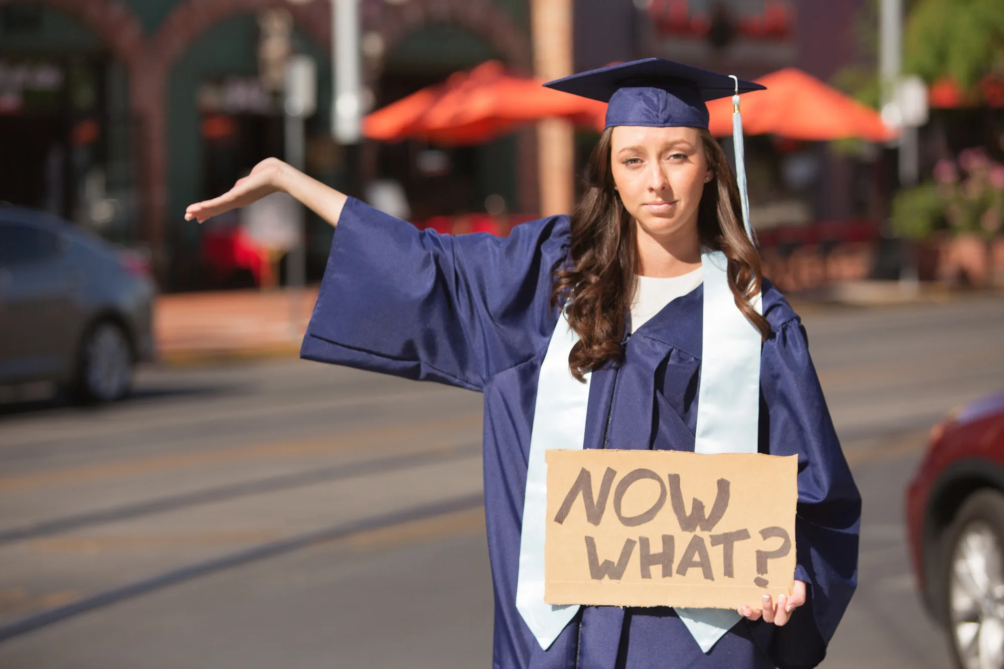 Serious female student holding hand out with cardboard sign