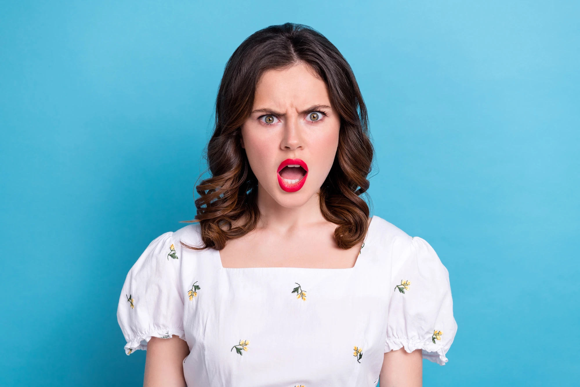 Photo portrait of lovely young lady scream shout offended frowning wear trendy white garment isolated on blue color background.