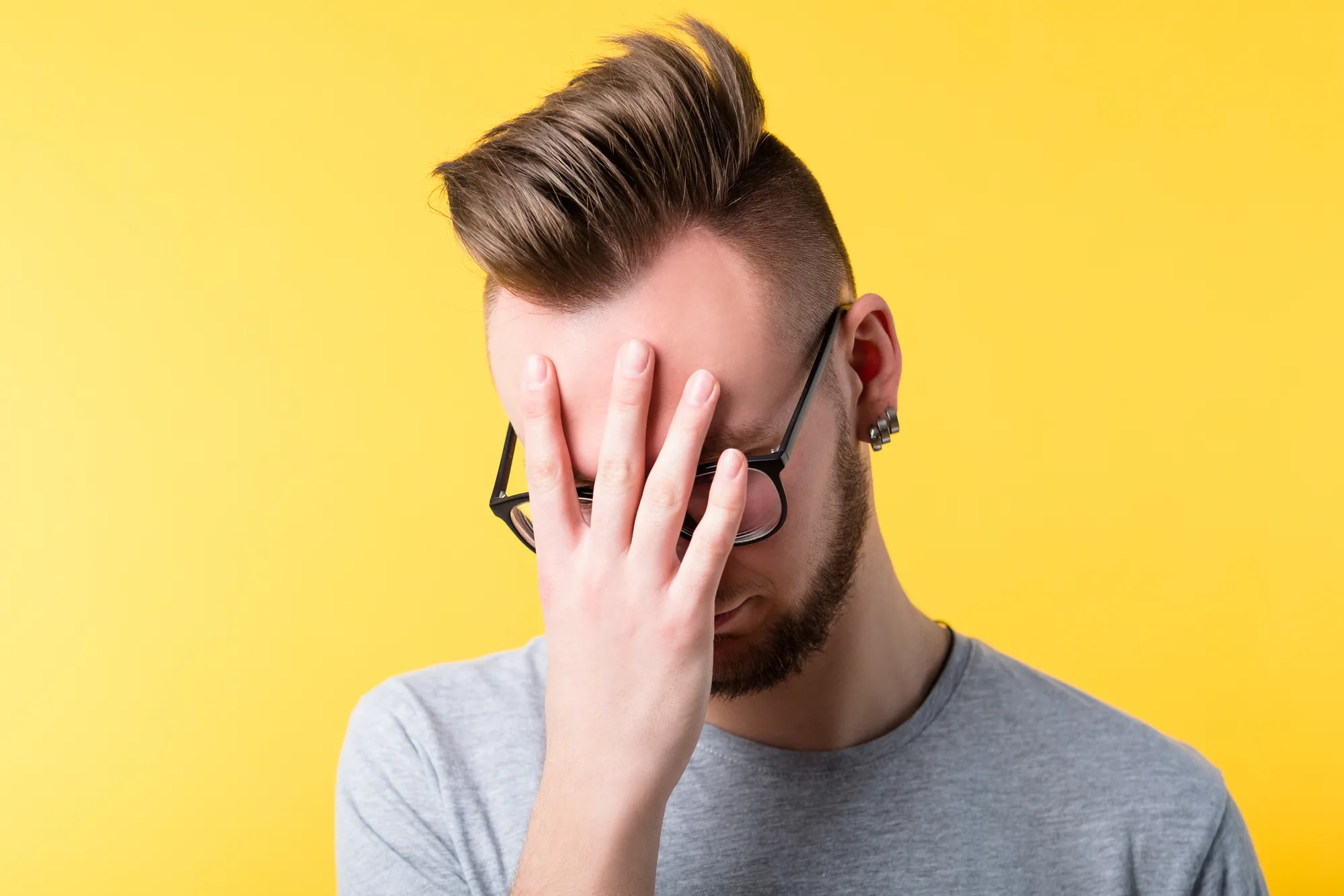 Omg wtf. Tired bored stressed young man covering face with palm. Bothered upset guy. Mistake job loss unemployment.