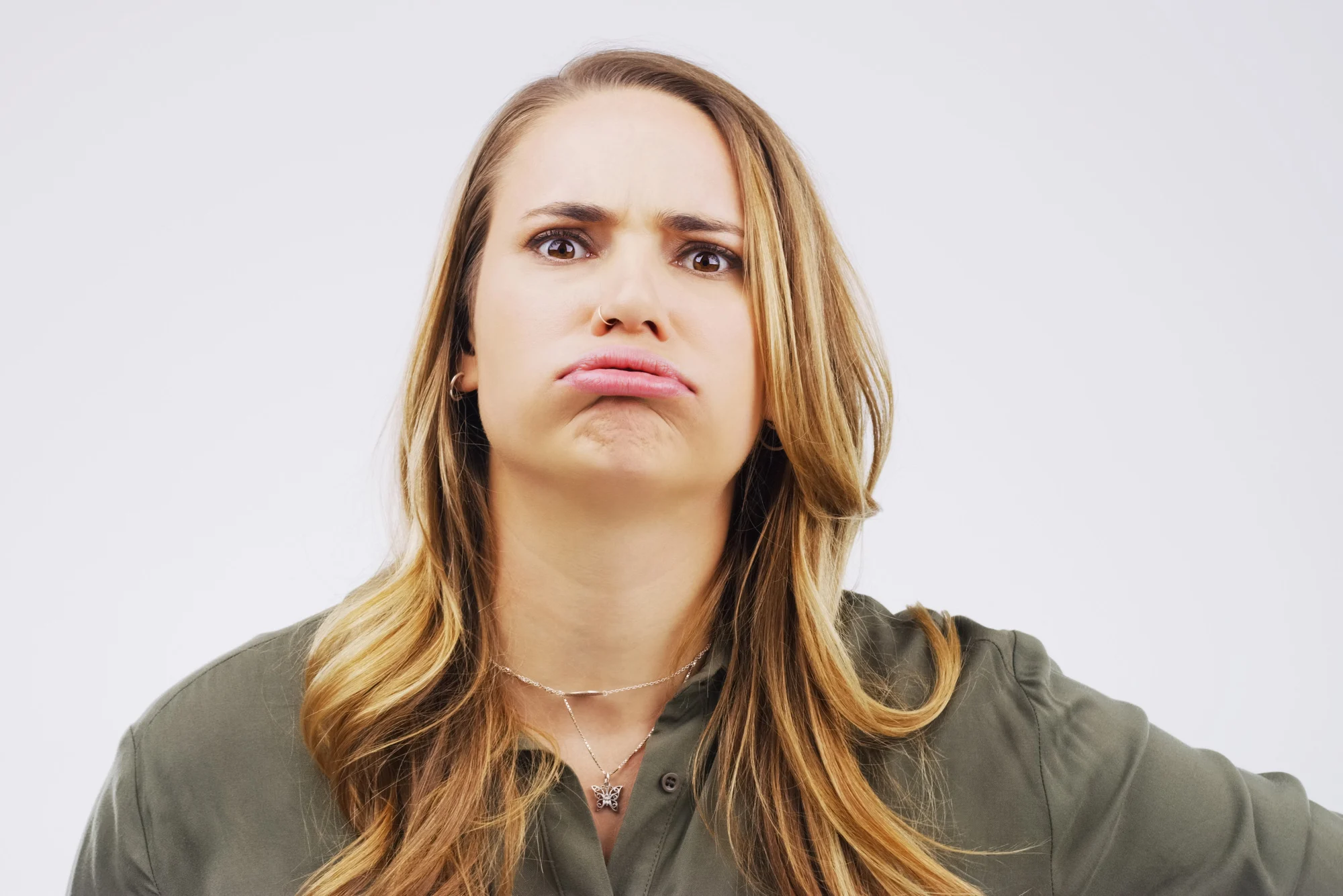 I dont want to. Studio shot of a young woman making a funny face against a gray background