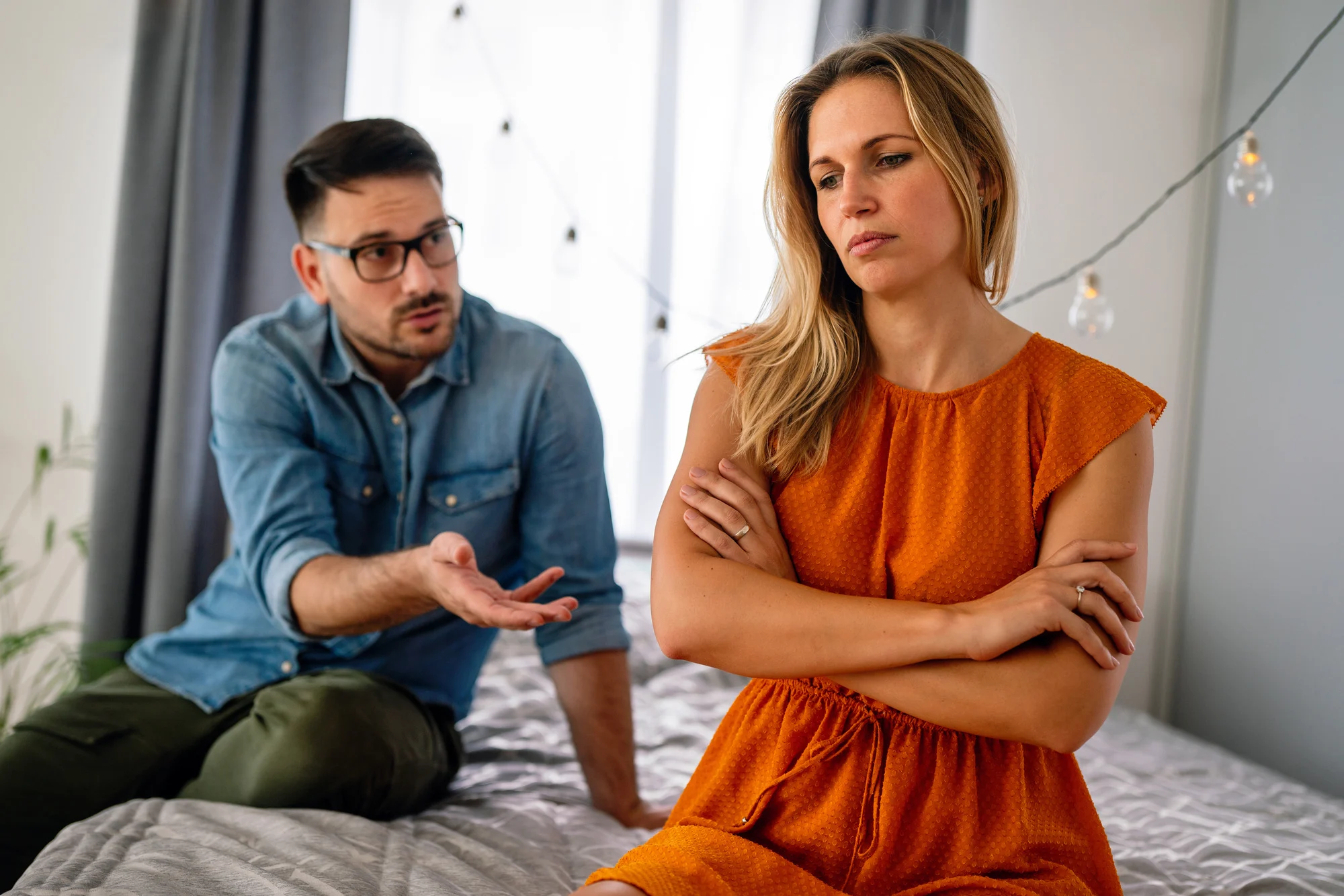 Sad pensive couple thinking of relationships problems sitting on sofa, conflicts in marriage, upset couple after fight dispute, making decision of breaking up get divorced