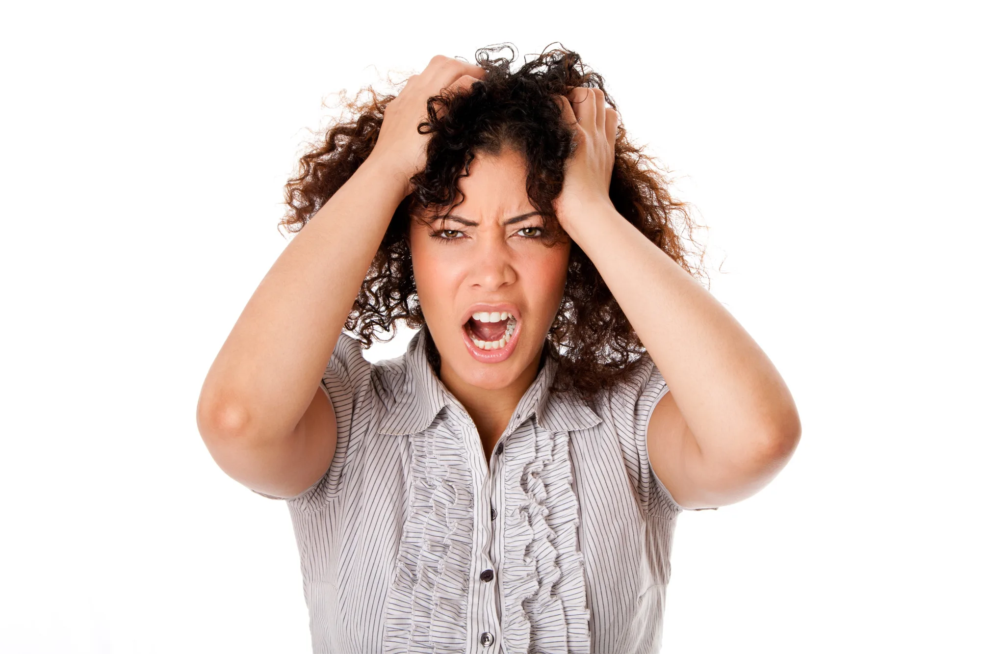 Frustrated angry stressed formal corporate business woman with curly hair with hands in hair and screaming yelling, isolated.