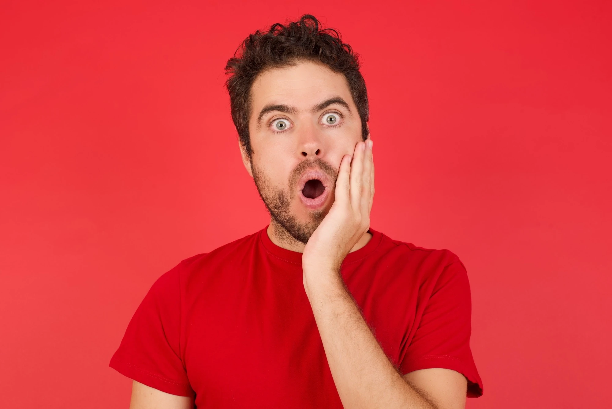 Horizontal portrait of shocked caucasian male models against yellow background looks with great surprisment being very stunned, astonished with unexpected news, . Facial expressions concept.