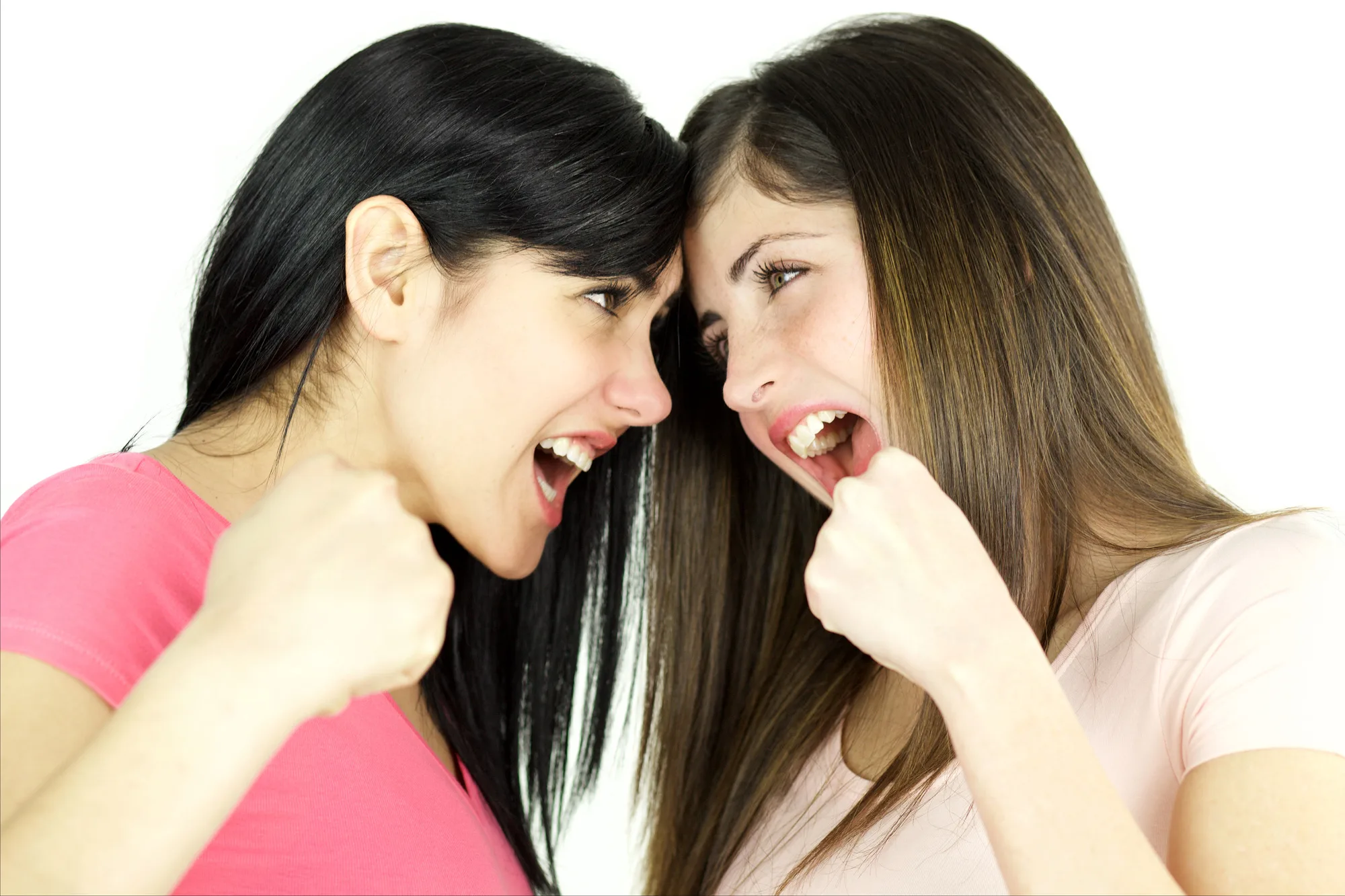 Beautiful women fighting angry looking each other strong expression isolated.