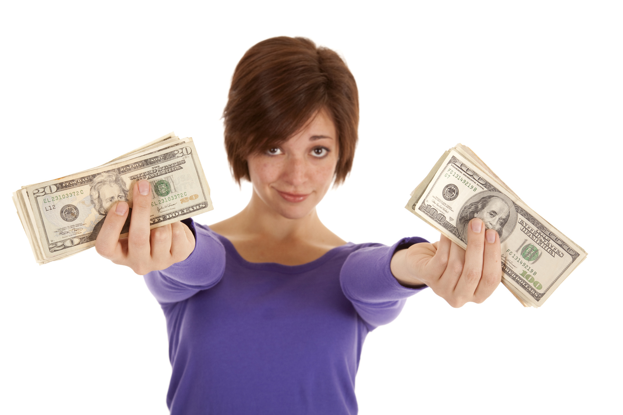 A woman with a serious expression on her face holding out her money in her hands.