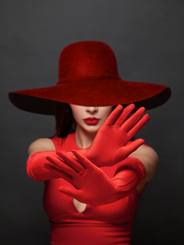 Stop gesture. Brunette woman hands in red silky gloves and wide broad brim hat showing stop gesture, negation, denial and no. Stop violence concept