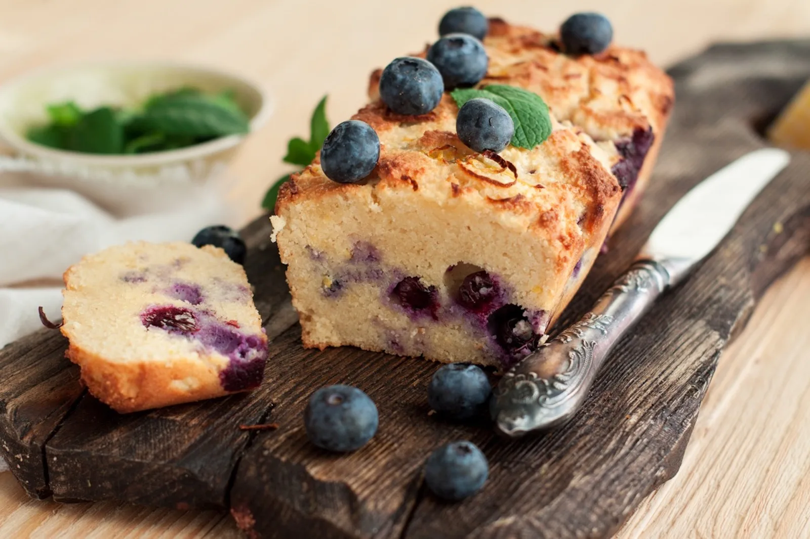Healthy vegan sweet lemon bread with blueberries on rustic cutting board